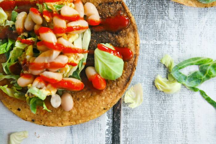 This Gluten Free Tostadas recipe is made with egg and white beans, and it's topped with a spicy chili sauce. It's a great vegetarian meal any time of day!