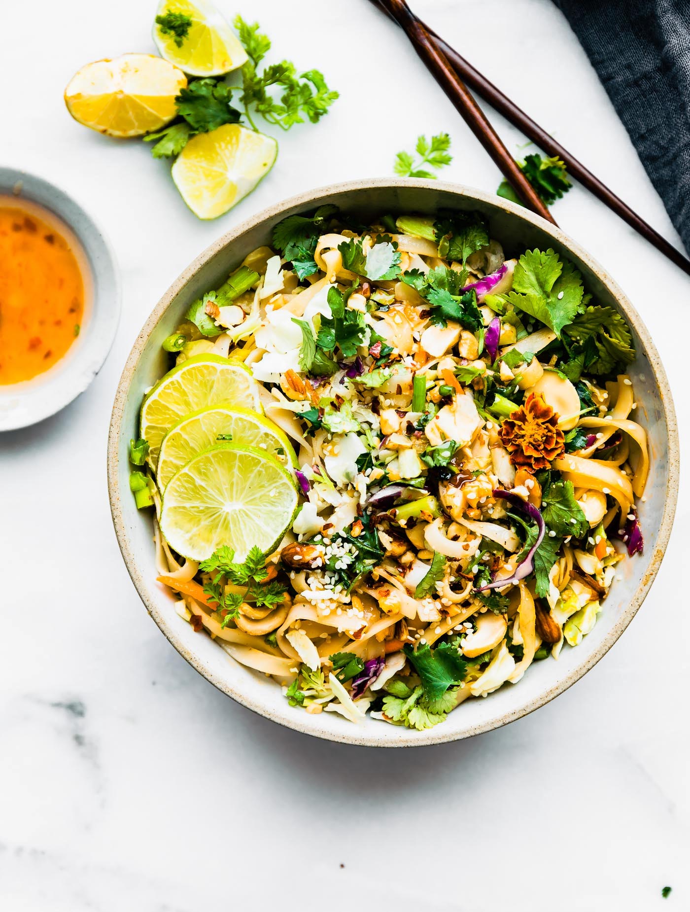 Spicy Thai rice noodle salad in bowl on white counter.
