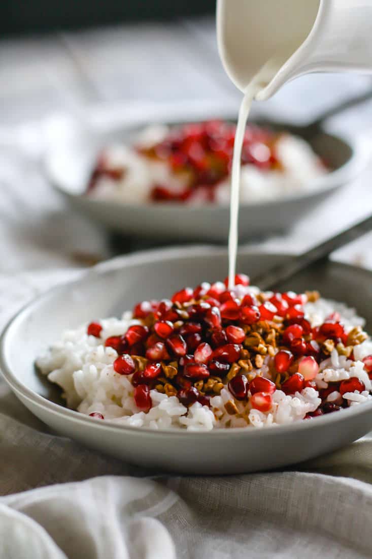 Coconut Rice and Pomegranate Porridge! Good carbs do exist! This gluten free and dairy free breakfast porridge makes for great performance fuel! A nourishing dish made with jasmine rice, coconut milk or cream, cinnamon, maple syrup, nuts, and cinnamon. The perfect combo of nutrient dense foods.