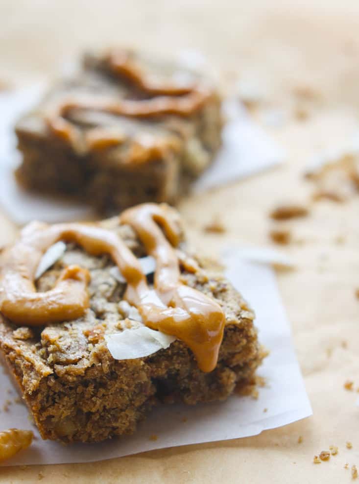 A simple, delicious grain free trail mix blondie bar made with dried fruit, nuts, honey/coconut sugar, and nut butter! Naturally sweetened, easy to make, and perfect for travel, snacks, breakfast, or a healthy dessert alternative! Want to add more nutty flavor? Top with homemade peanut butter frosting