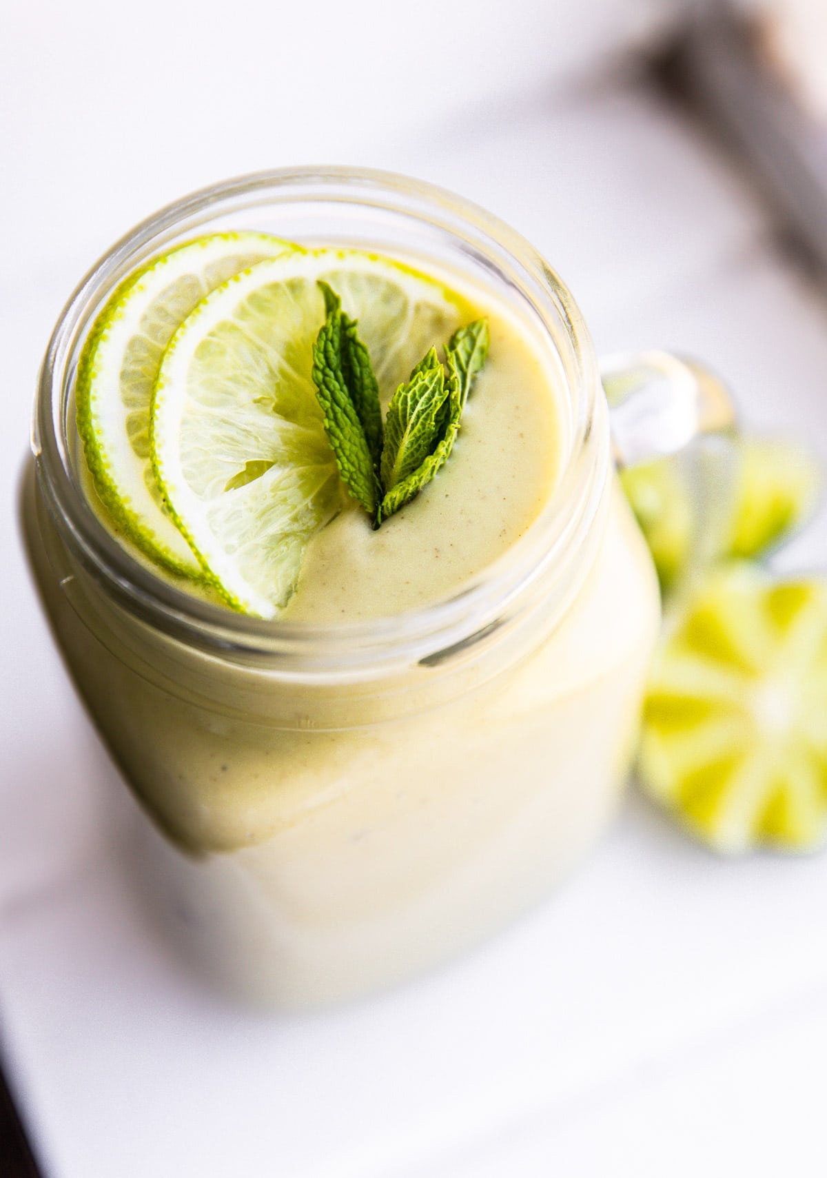 keto avocado smoothie with lime and mint in mason jar glass