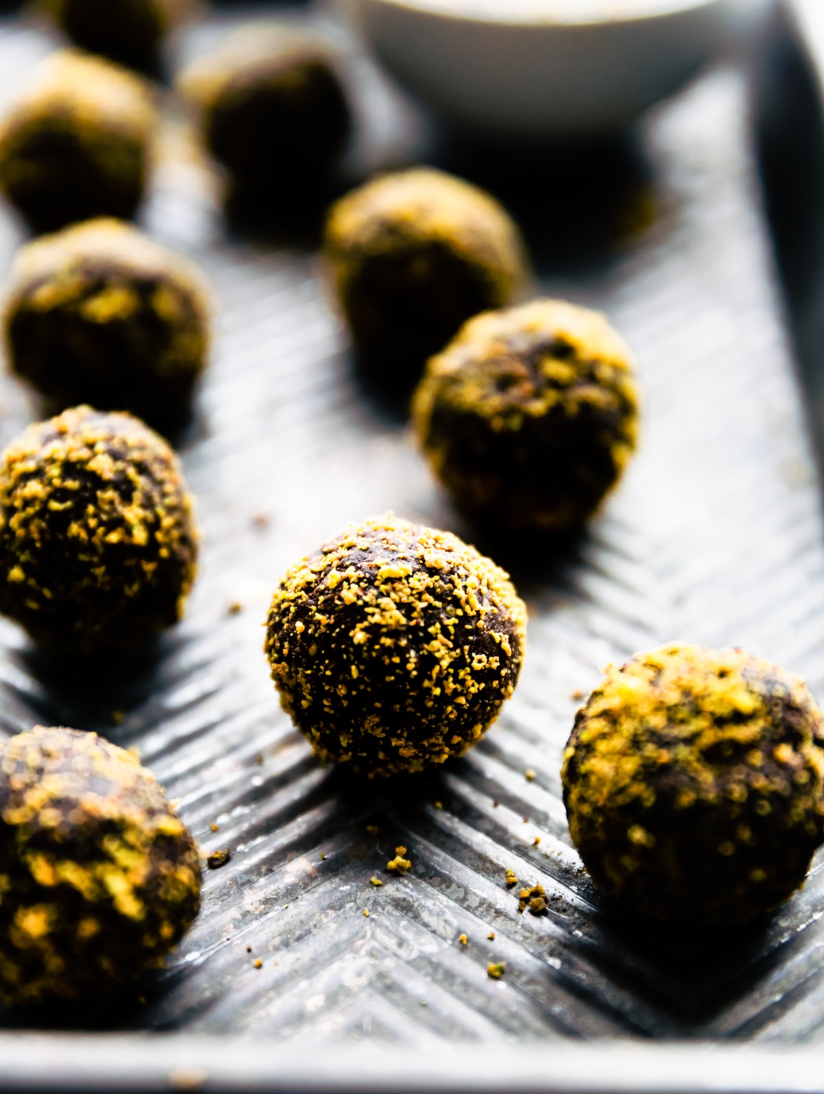 dark chocolate pistachio protein balls on baking sheet.
