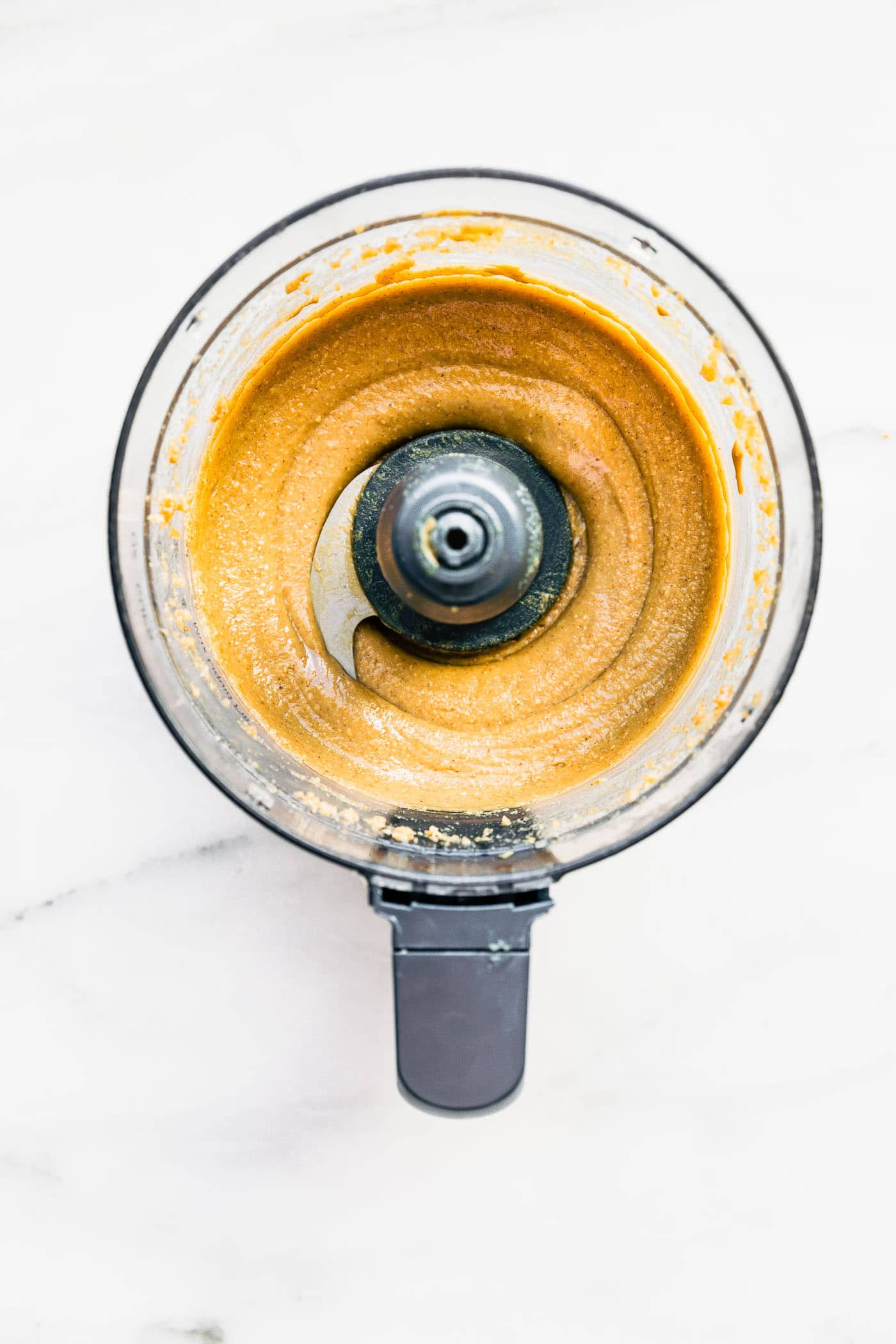 Overhead image of cashew butter in a food processor.