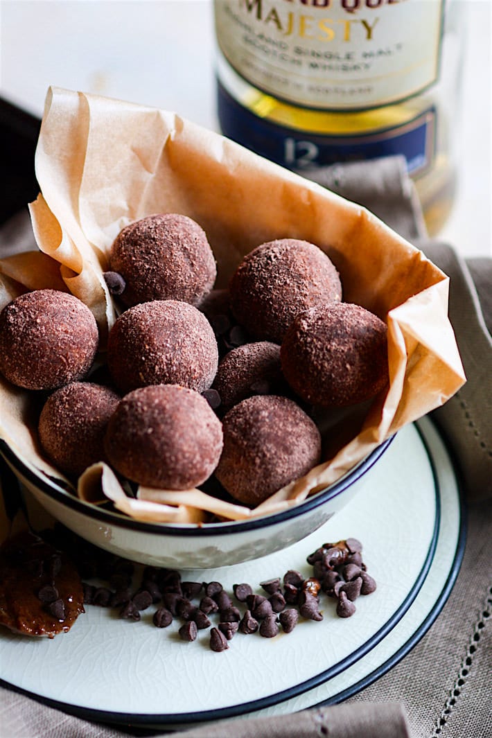 No Bake Dark Chocolate Whiskey Cake Bites!! These rich and decadent dark chocolate whiskey cake bites are so delicious and simple to make with REAL ingredients. Gluten free and non alcoholic versions as well. Great for a healthier dessert or fun party snacks. Cheers!