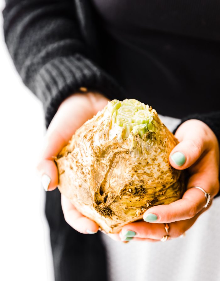 Two hands holding a celery root