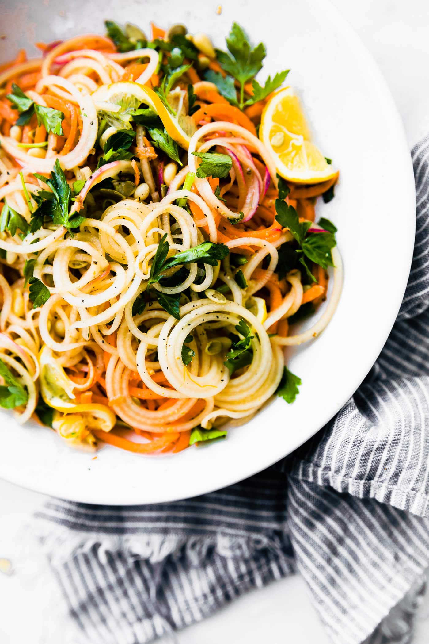 Light and Zesty Carrot Celeriac Spiralized Salad! This marinated vegetable spiralized salad is simple and healthy to make, not to mention delicious! A paleo, vegan, and whole 30 friendly veggie noodle salad option you can make under 30 minutes. #vegan #paleo #whole30 #salad