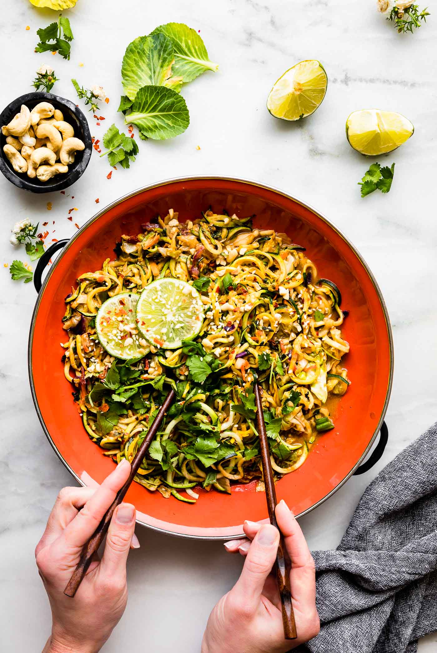 Satay style stir fry zoodles in a skillet made paleo, vegan, and gluten-free on a table top.