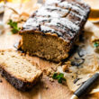 Loaf of Irish Cream Banana Bread with end cut off to show inside texture on a wooden cutting board.