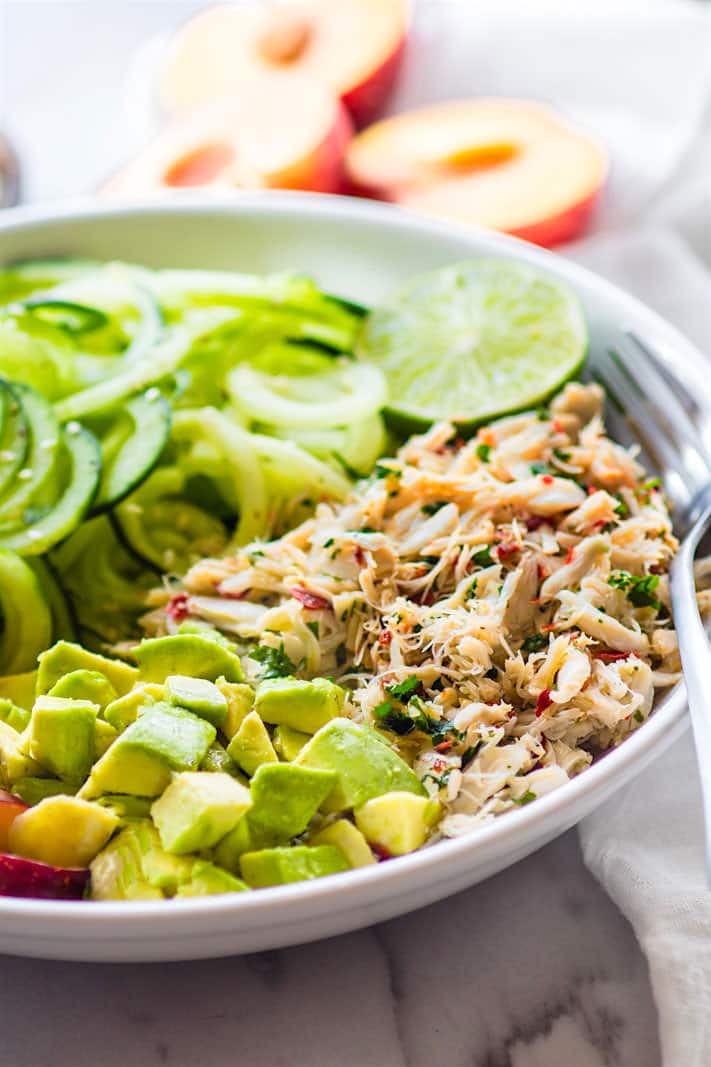 Seafood lovers rejoice! You'll love this Power Lunch Paleo Asian Crab and Avocado Spiralized Cucumber Salad! Light, Gluten Free, and Super Healthy crab and zesty spiralized cucumber salad topped with avocado and juicy plum. Protein packed and nutrient dense!