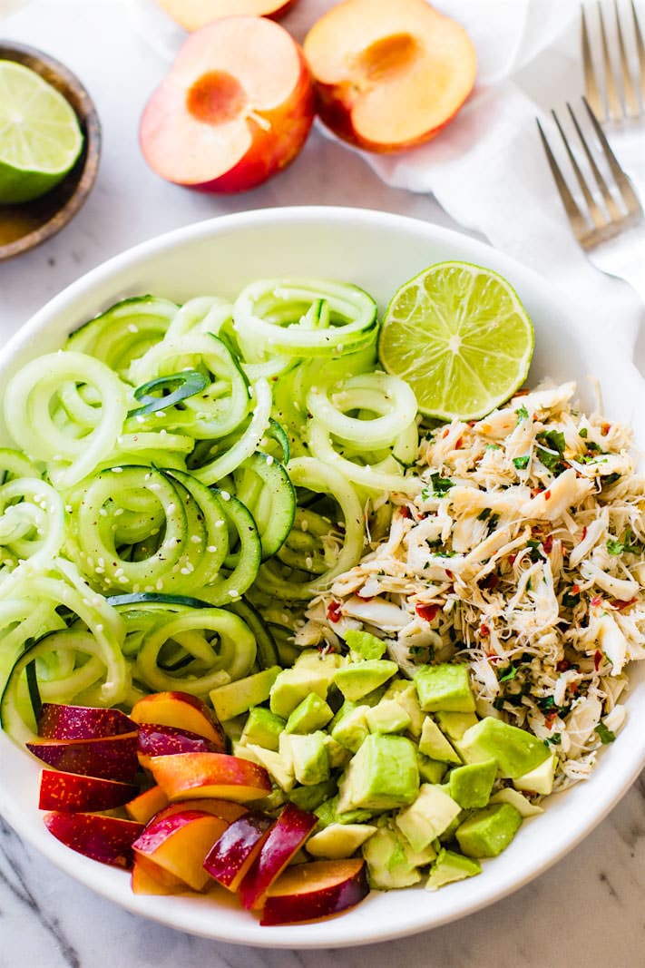 Seafood lovers rejoice! You'll love this Power Lunch Paleo Asian Crab and Avocado Spiralized Cucumber Salad! Light, Gluten Free, and Super Healthy crab and zesty spiralized cucumber salad topped with avocado and juicy plum. Protein packed and nutrient dense!
