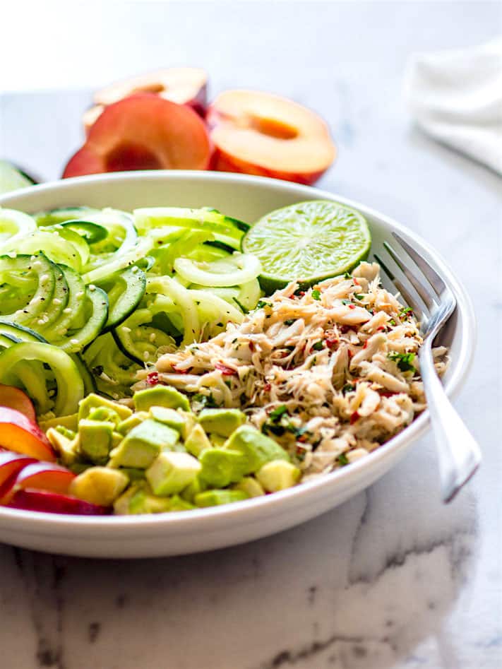 Power Lunch Paleo Asian Crab and Avocado SPiralized Cucumber Salad! Light, Gluten Free, and Super Healthy crab and zesty spiralized cucumber salad topped with avocado and juicy plum. Asian style crab salad that makes for a great protein packed and nutrient dense lunch, appetizer, or main meal. @cottercrunch