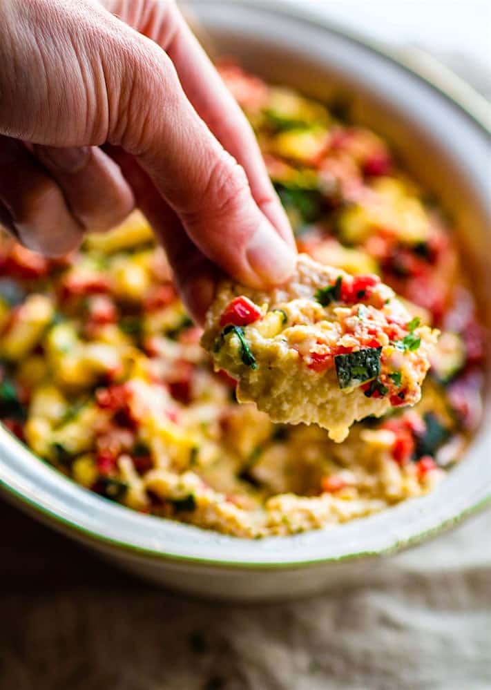 Easy Parmesan and Roasted Garlic Baked Hummus Dip with Zucchini and Pimentos! A super simple gluten free baked hummus dip recipe that feeds a crowd! So delicious, healthy, veggie packed, and addicting...in the best possible way.