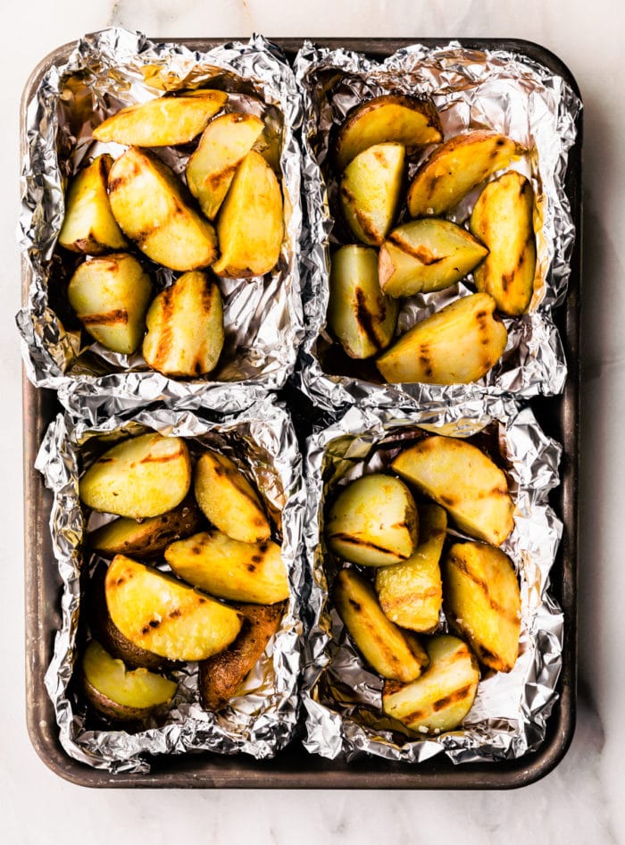 close up photo of grilled potatoes in aluminum foil packets