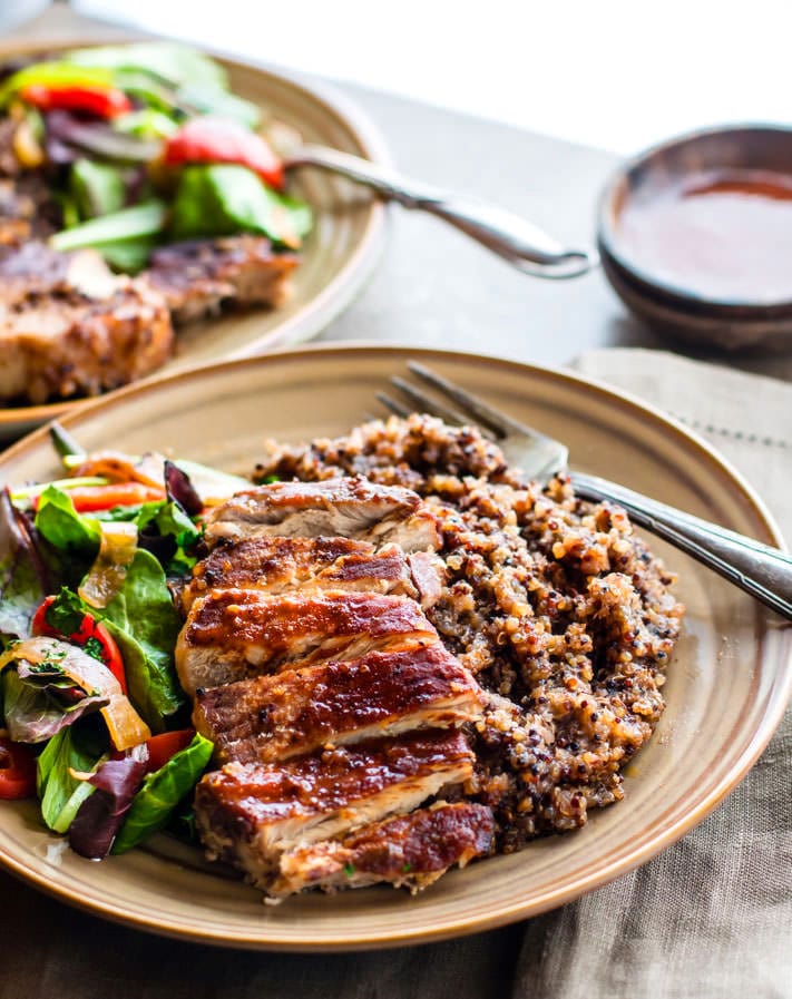 bbq pork chops on a plate with quinoa and salad