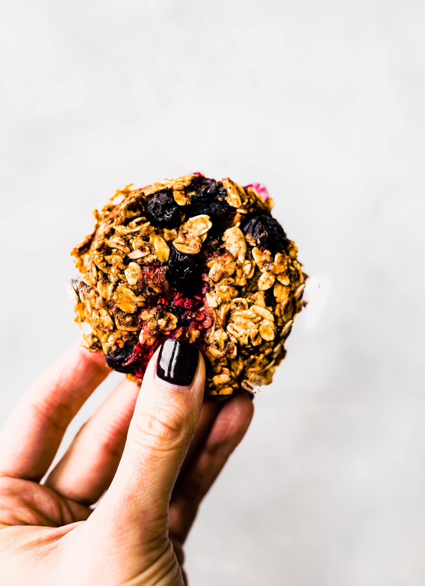 woman holding oatmeal berry cookie in hand