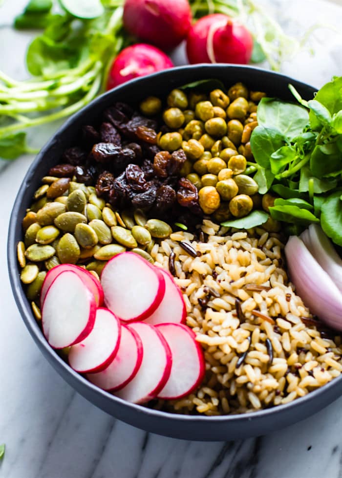 Nourishing Garden Veggie Vegan Buddha Bowl! This wholesome and healthy Buddha bowl recipe, (aka hippie bowls) is filled with ancient, garden veggies, crunchy peas and seeds, and lots of superfood ingredients. A delicious way to get a variety of nutrients packed all in one gluten free bowl!