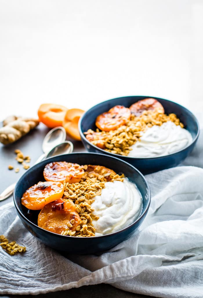 Gluten Free Char-grilled apricot parfait dessert bowls! These dessert bowls are great for dessert or breakfast. A light and simple dessert that's layered across with glazed grilled apricots, whipped coconut cream, and wholesome granola.