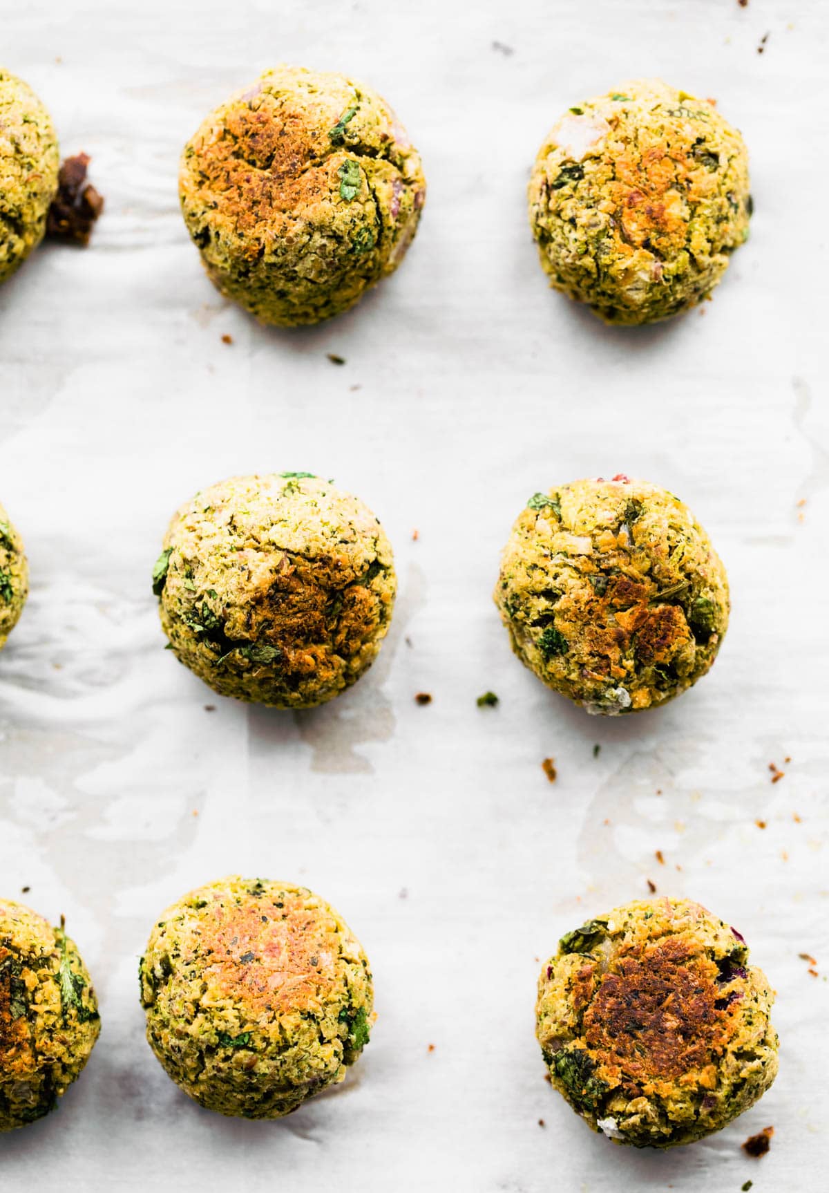 Baked Mexican vegan falafel balls lined up on parchment paper