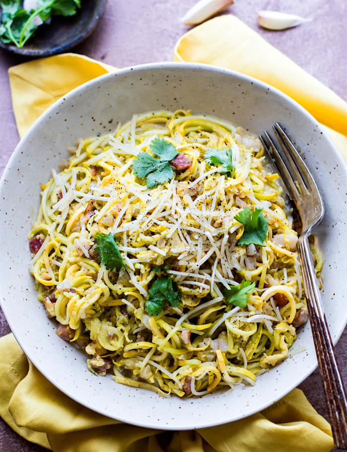 Quick Spiralized Squash Carbonara with Pancetta! Delicious spiralized squash noodles, pan fried garlic and pancetta, and a creamy pasta carbonara sauce all tossed together. This low carb veggie pasta dish is super easy to make with a spiralizer. A light pasta carbonara comfort food dish that's naturally gluten free.