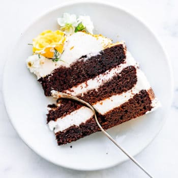 slice of chocolate layer cake on white plate with fork