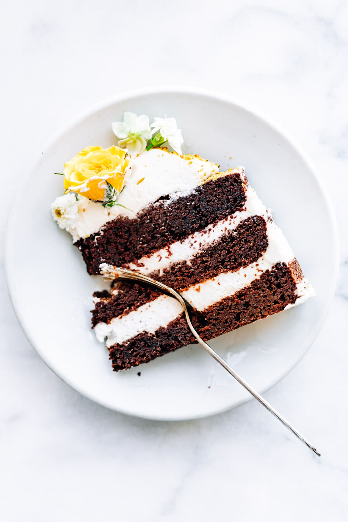 slice of chocolate layer cake on white plate with fork
