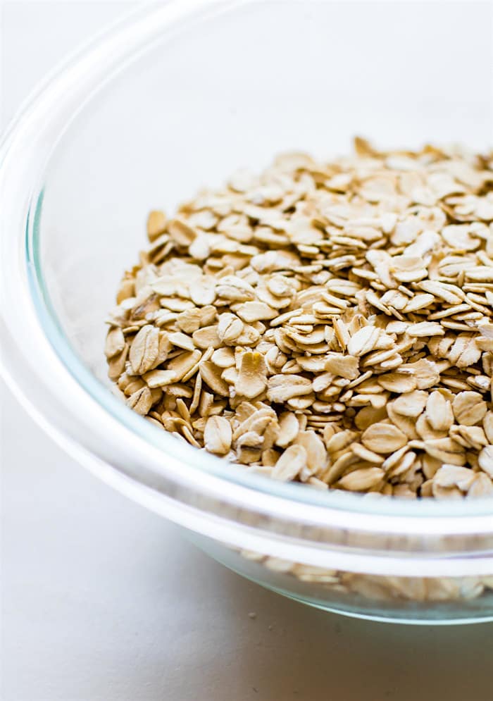 Oats in a clear glass mixing bowl.