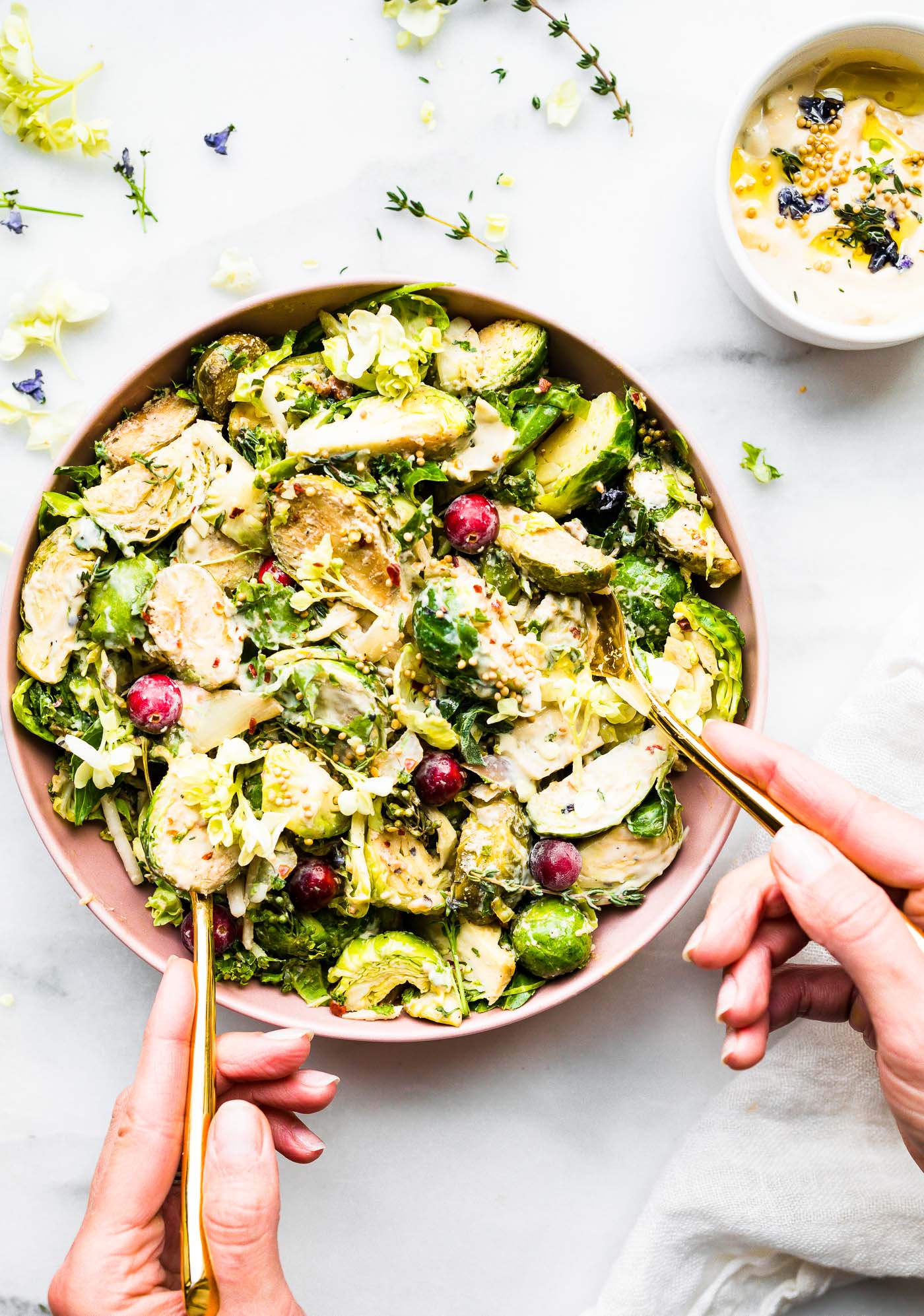 Overhead view pink bowl filled with Creamy Mustard Brussels Sprouts Salad with cranberries.