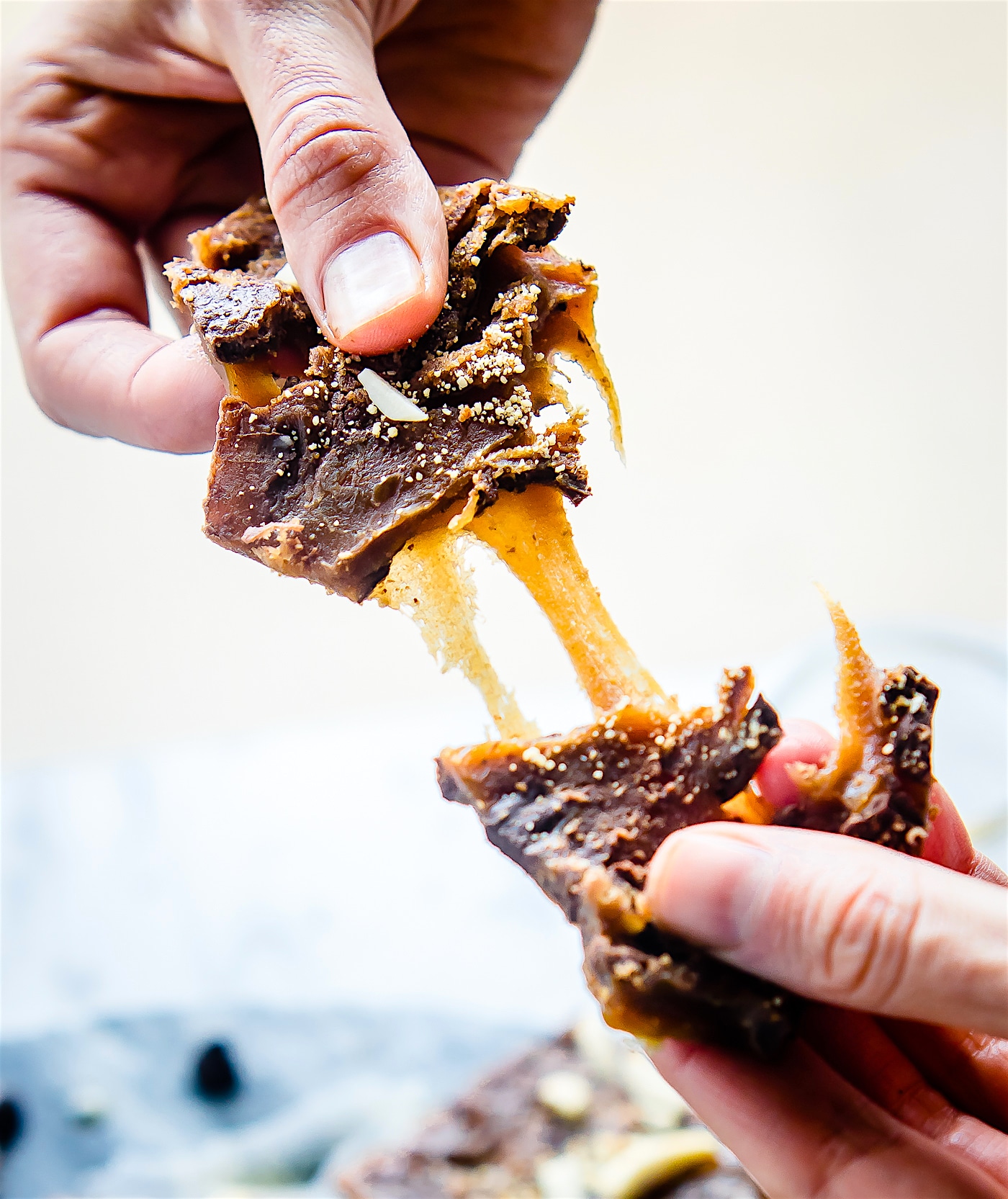 pulling apart a piece of gooey maple candy covered in dark chocolate