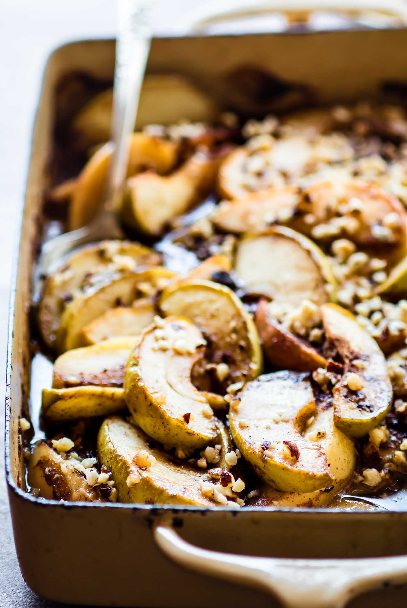 Caramelized Apple Cider Hot Fruit Bake with sliced apples and nut crumble in casserole dish