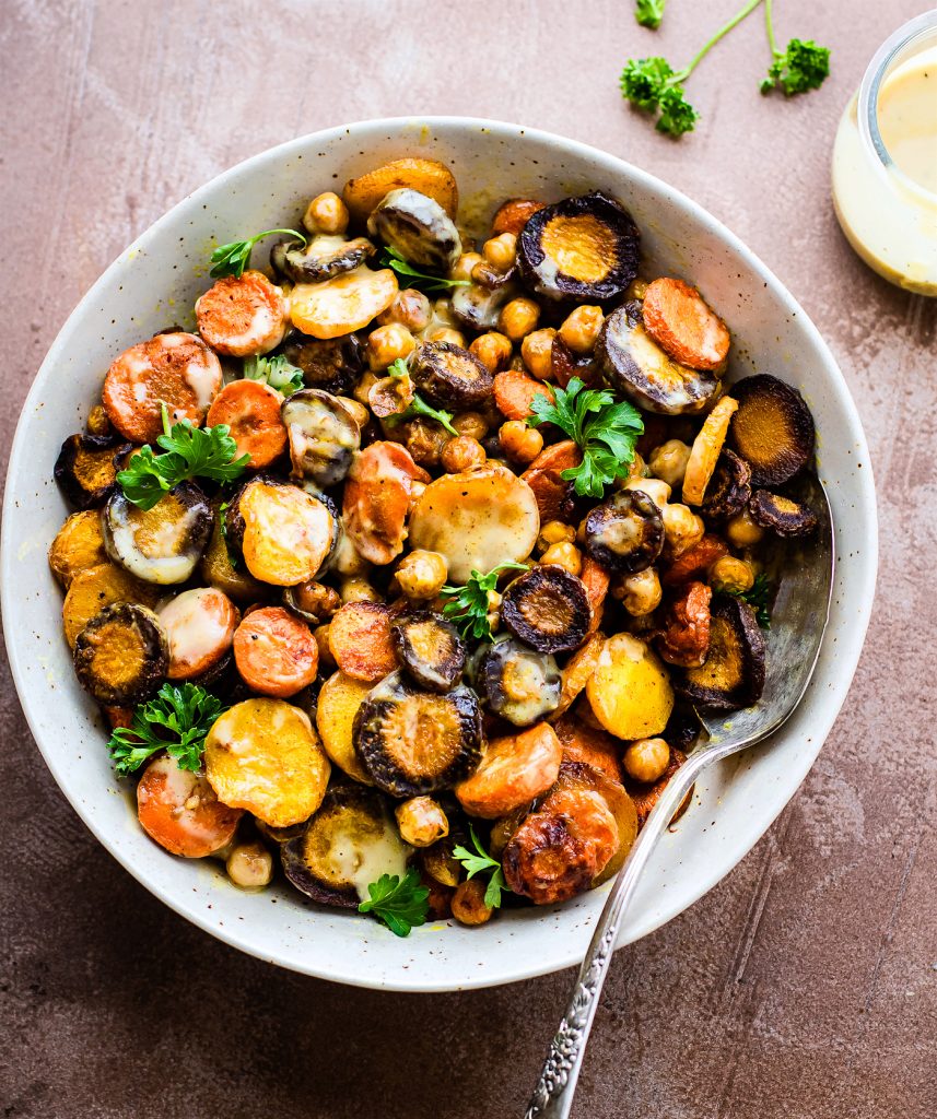 Tumeric Roasted Carrot Chickpea Salad with Apple Cider Tahini Dressing served in stone bowl