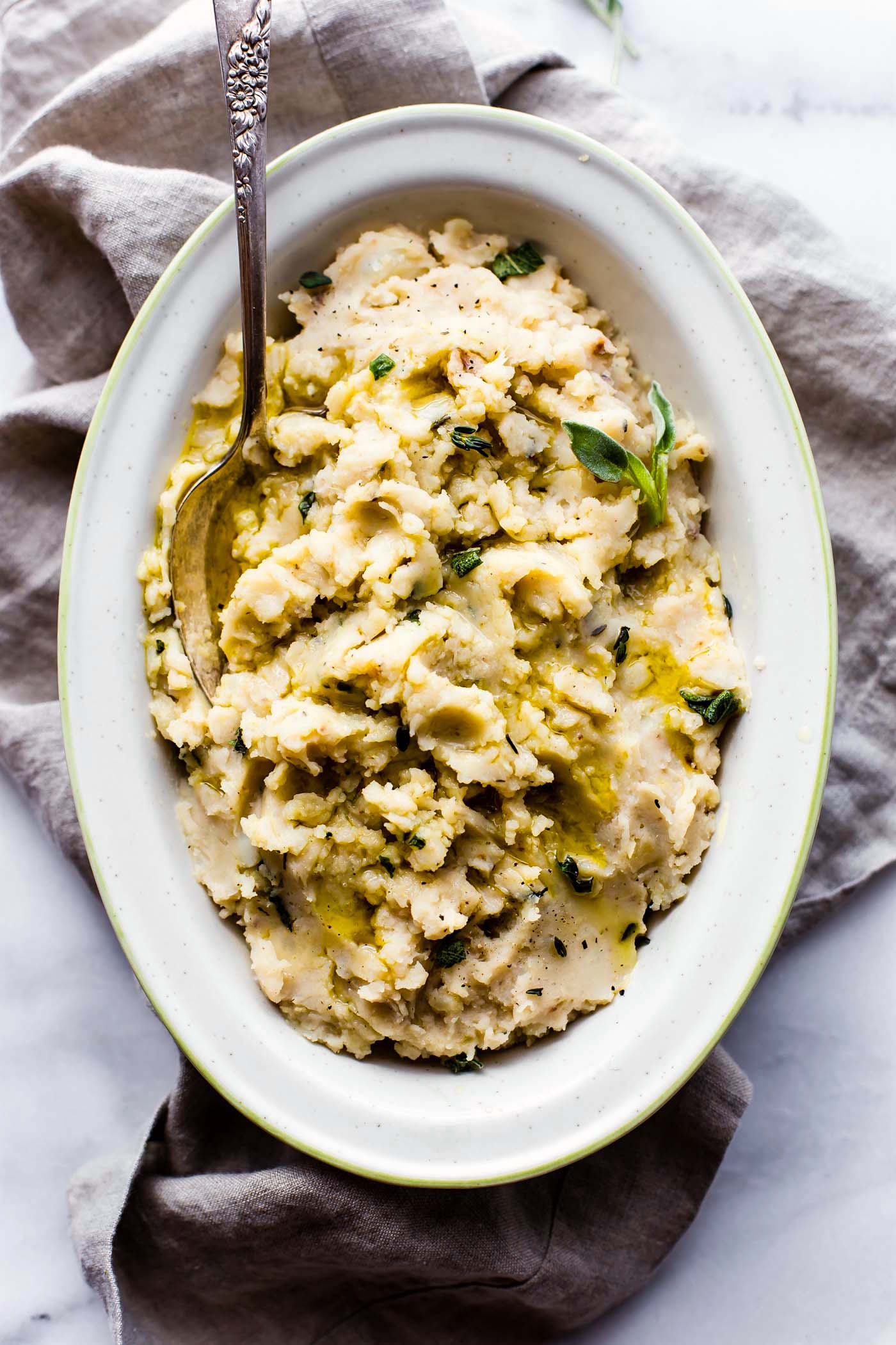 Slow cooker mashed potatoes with a creamy white bean and herb puree! These Vegan slow cooker mashed potatoes are so buttery and delicious, even without the butter! A simple, yet healthy, white bean sage puree is cooked right in to give it extra flavor and texture!. A vegan side dish that everyone will enjoy! 