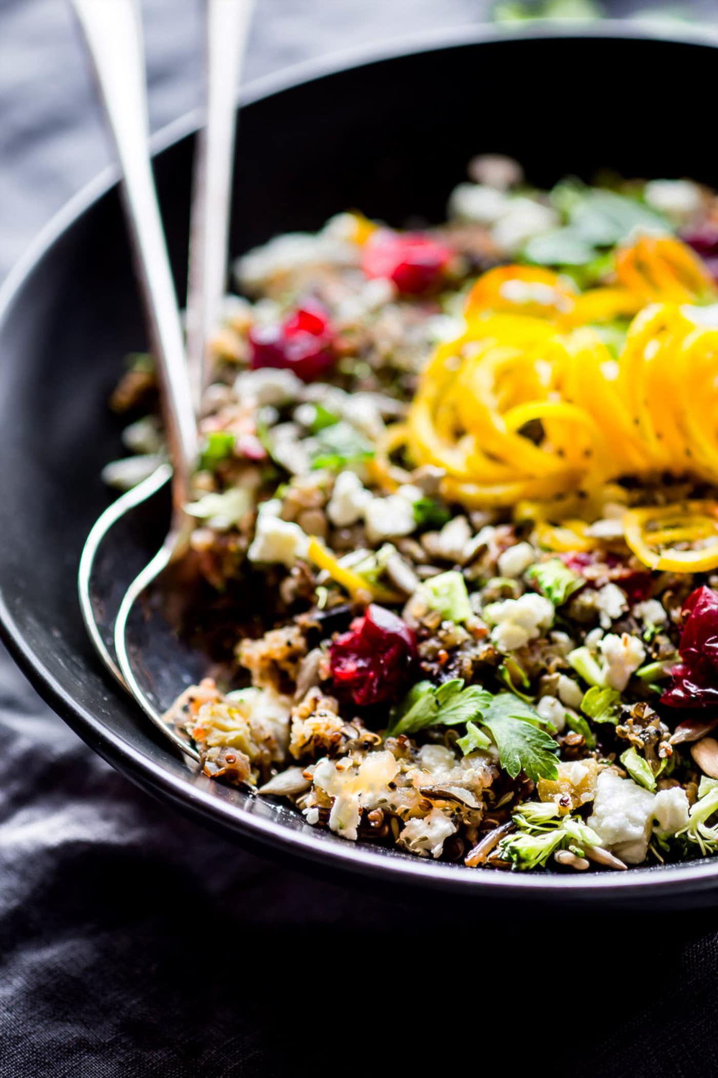 2 serving spoons in a bowl of vegetarian quinoa pilaf