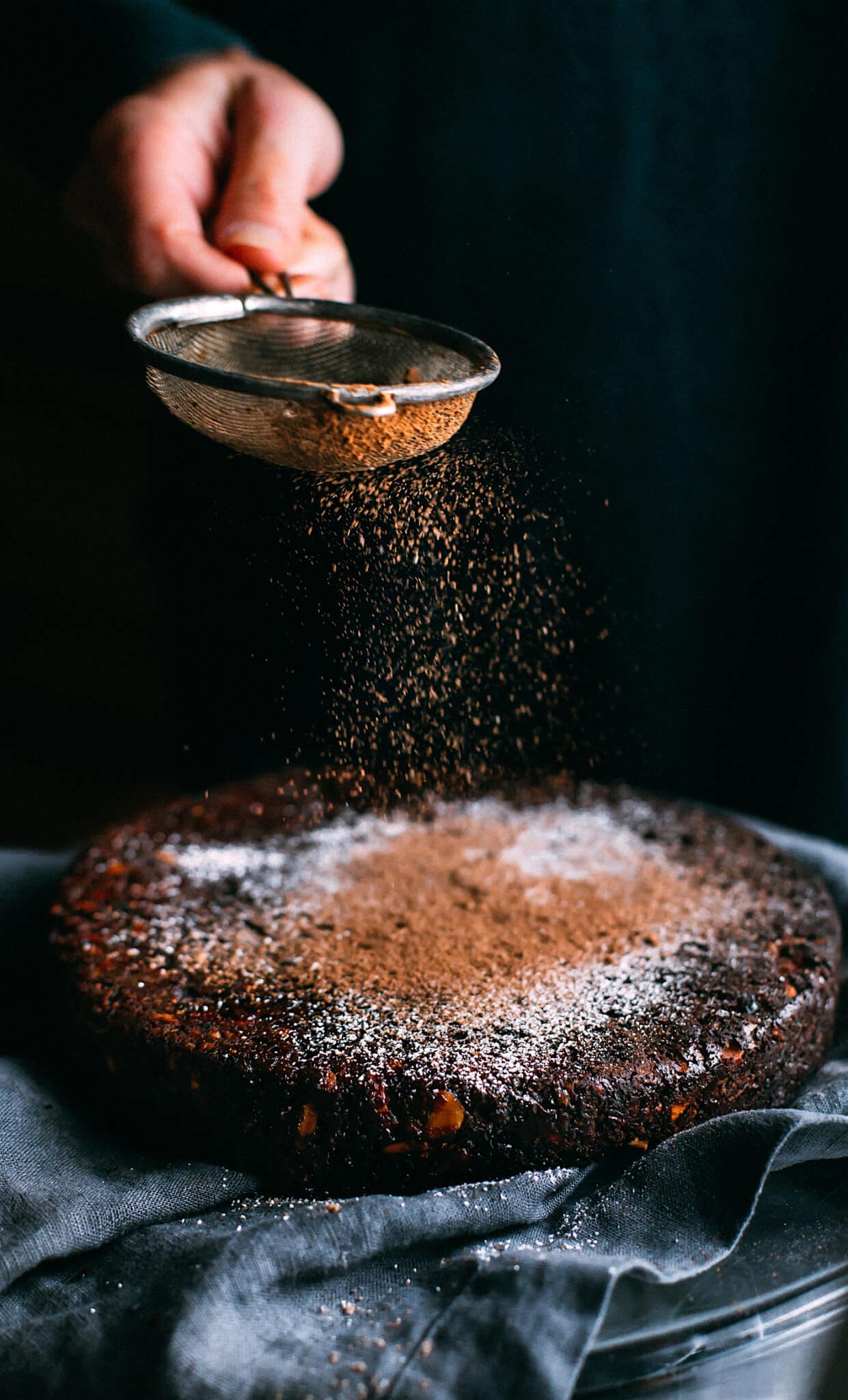 A dusting of cacao powder over a gluten free chocolate Christmas cake (panforte).