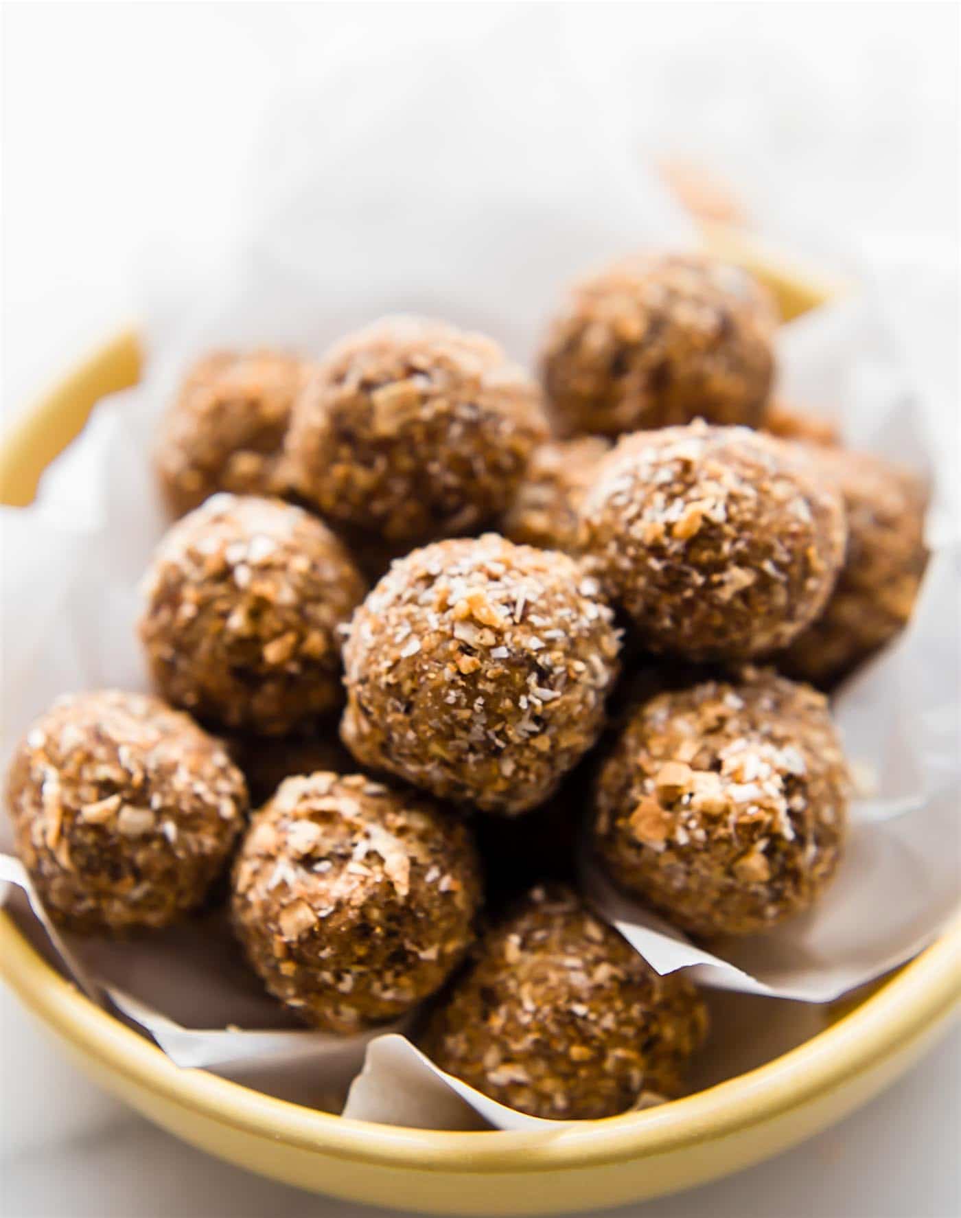 Toasted Coconut Bliss balls. in a yellow bowl