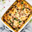 Southwest black beans polenta casserole in a white baking dish, topped with melted cheese.