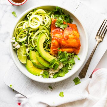 BBQ Baked salmon fillet over zucchini noodles and quinoa.