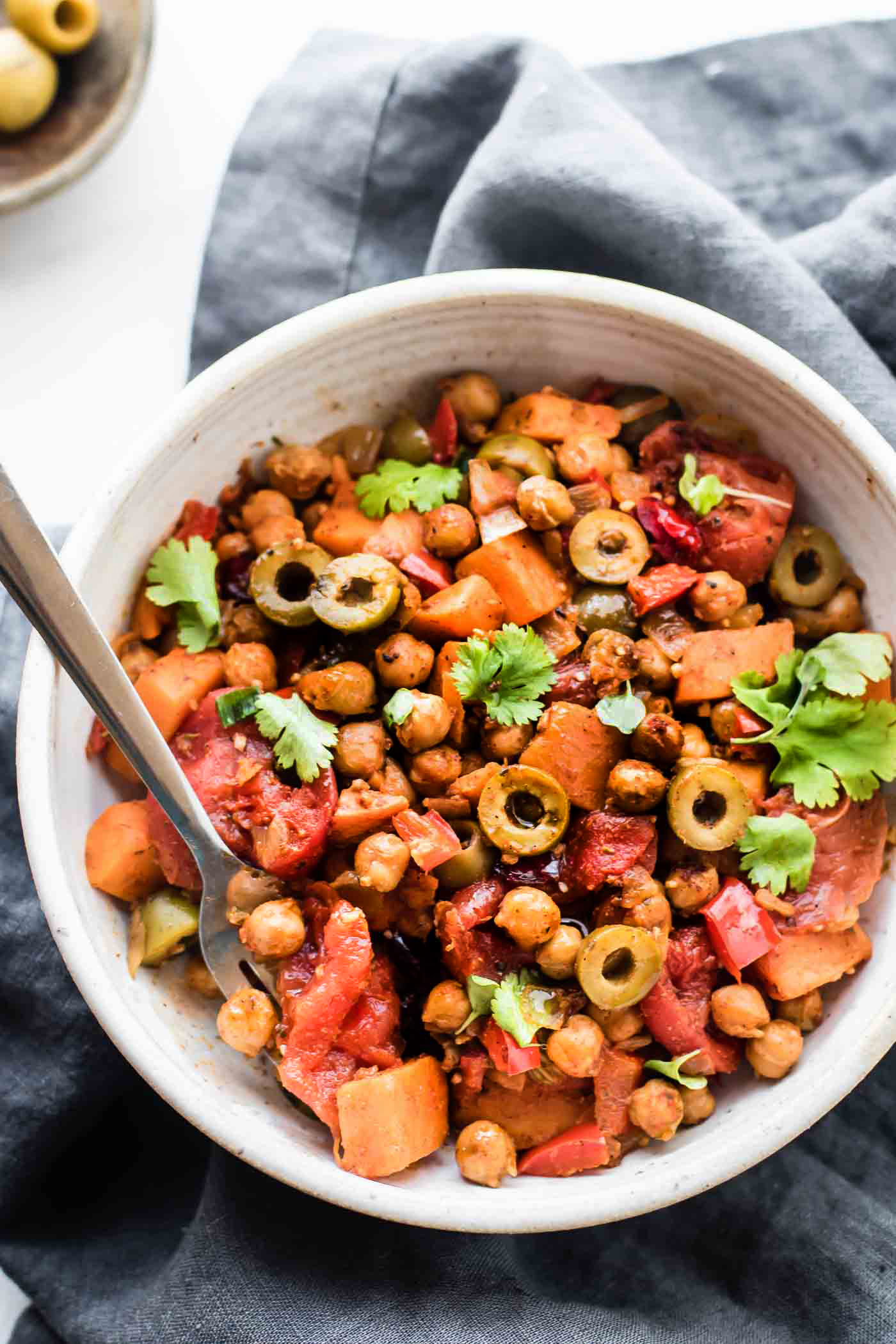 These Cuban Sweet Potato Picadillo Bowls make for a wholesome Latin-inspired weeknight meal! This vegan picadillo recipe is the perfect combo of sweet and savory. Stewed Tomatoes, roasted chickpeas, sweet potatoes, olives, raisins, and spices! Simple healthy ingredients made into a flavorful one pot meal. Gluten free, grain free, EASY!