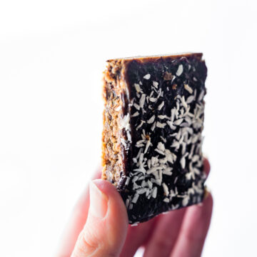 woman's hand holding up a Paleo Almond Butter Jelly Energy Bar