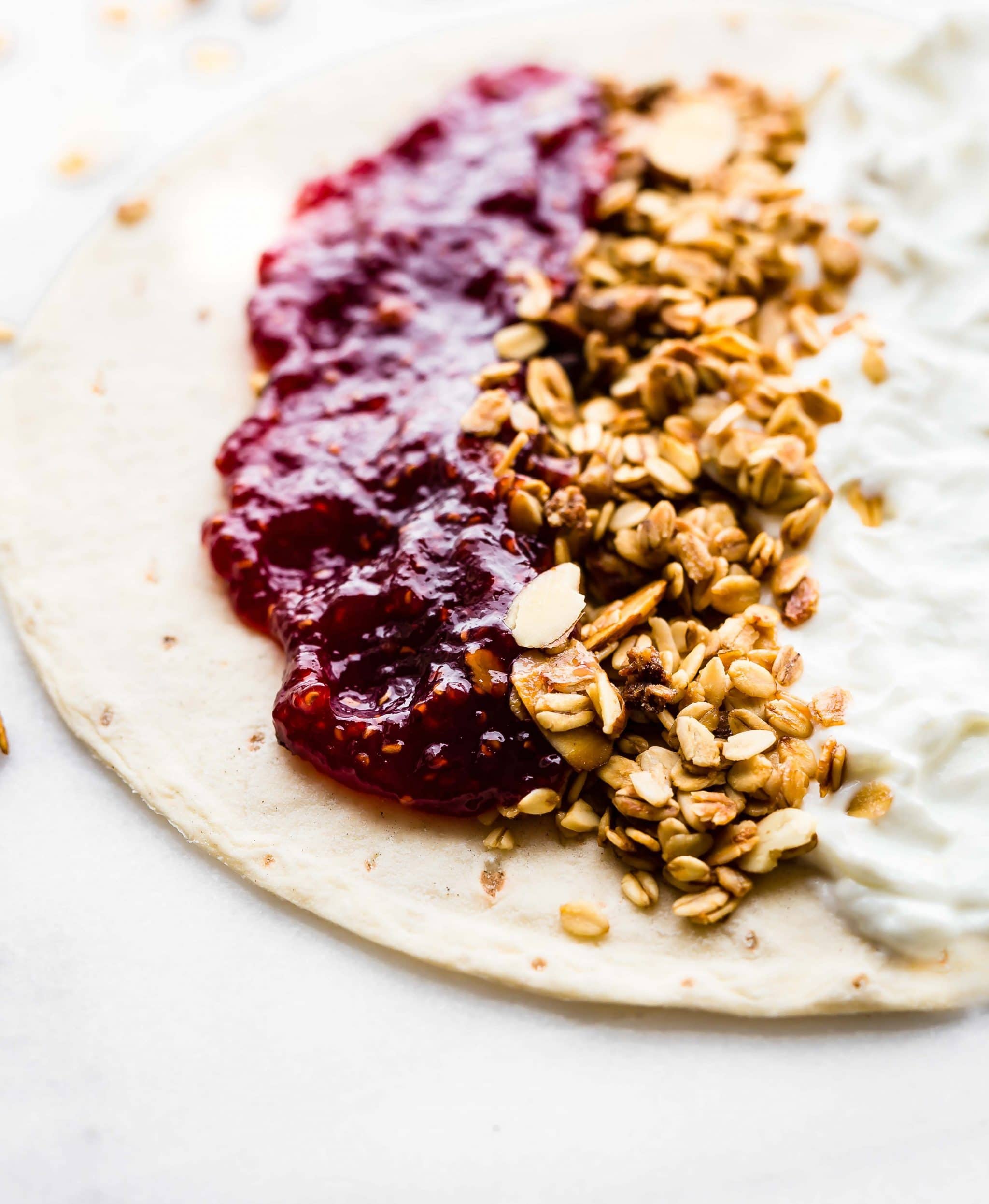 gluten free breakfast - raspberry preserves, gluten free oats and Greek yogurt spread onto a tortilla