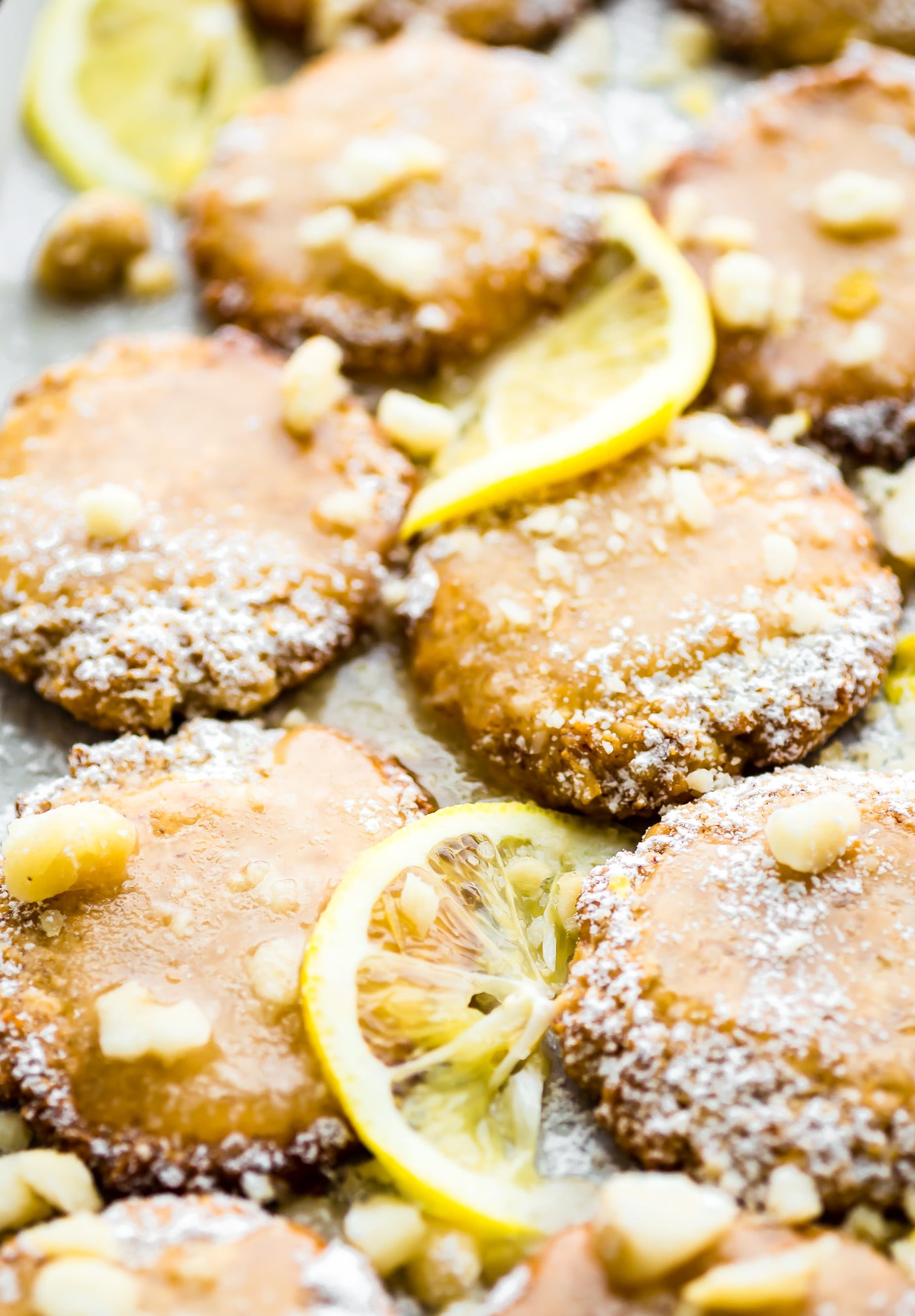 platter of macadamia nut cookies with lemon glaze surrounded by fresh lemon slices