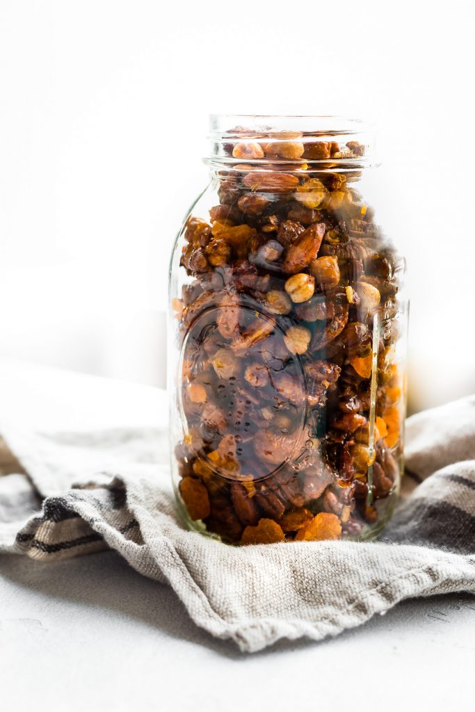 Instant Pot Candied Chickpea Cajun Trail Mix in tall mason jar against white background.