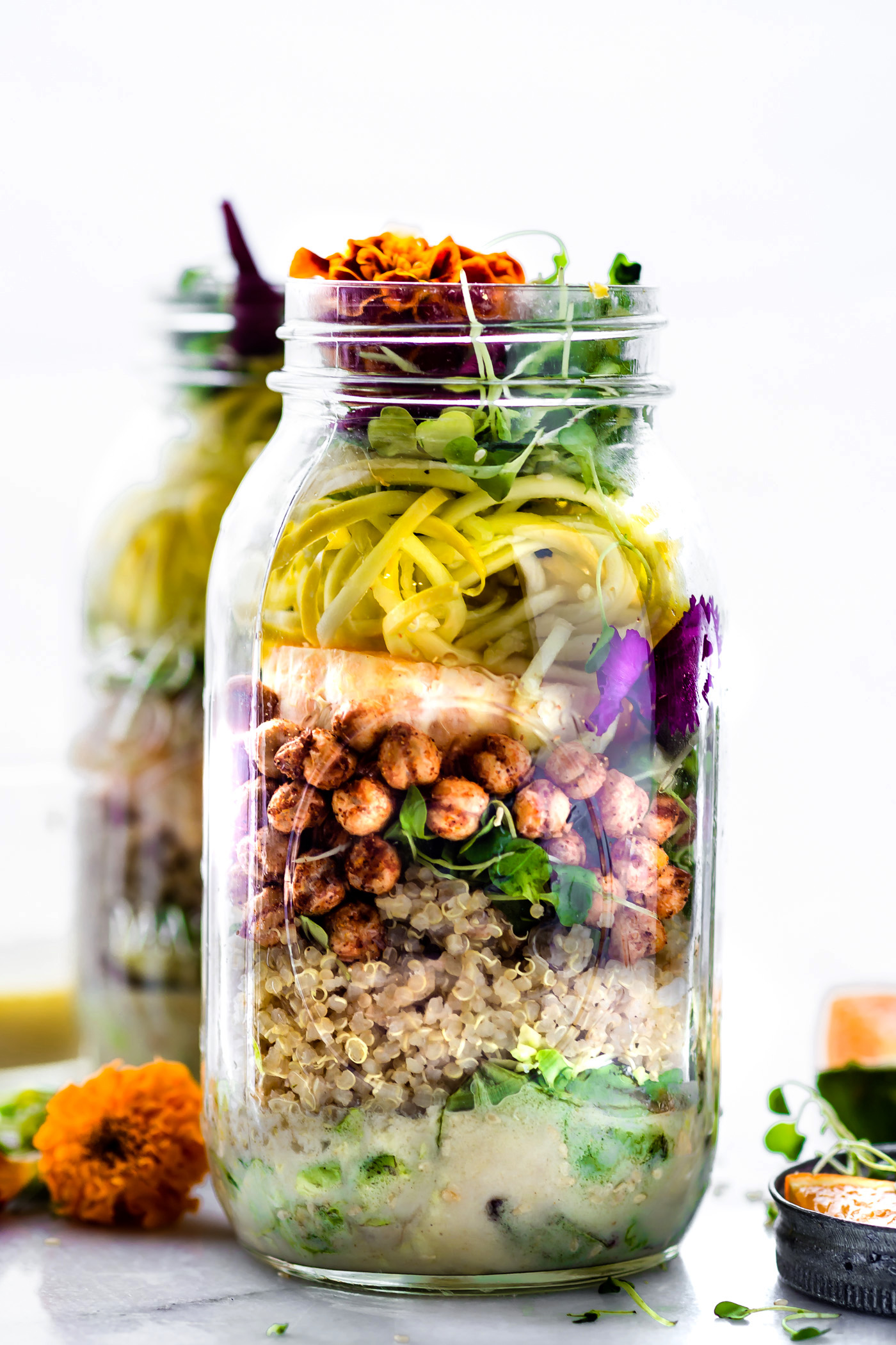 Mason jar salads are healthy, portable salads, picnic ready and packed with nourishment! This vegetarian Mason Jar Salad will keep you fueled and energized all day! Seasonal vegetables, roasted chickpeas, and a homemade sesame yogurt dressing make for a perfectly balanced lunch at home or on the go.