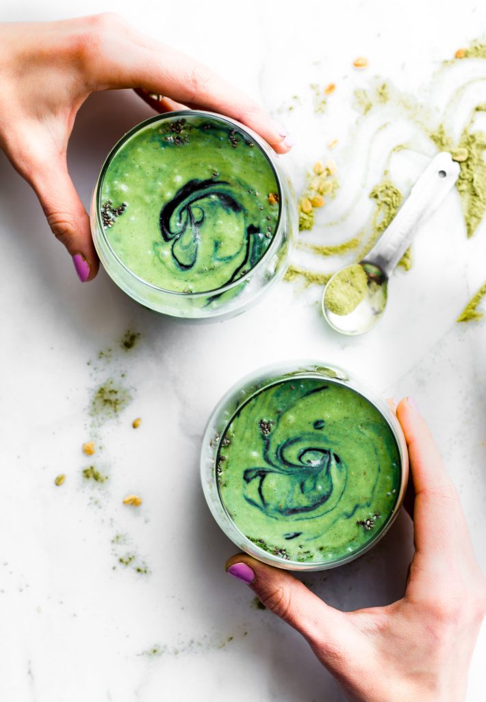 Two glasses filled with Superfood Coconut Smoothie being held 