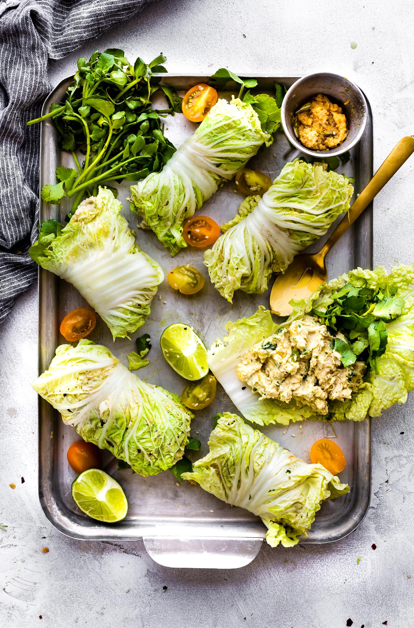 Miso Mango Chicken Salad Cabbage wraps are the perfect light low carb lunch that's easy to make! A mango chicken salad that's mayo free, paleo friendly, and flavorful! Spread the miso mango chicken salad mixture over napa cabbage, add a little bit of watercress, then firmly roll up! Bam, a perfectly handy lunch or light dinner!