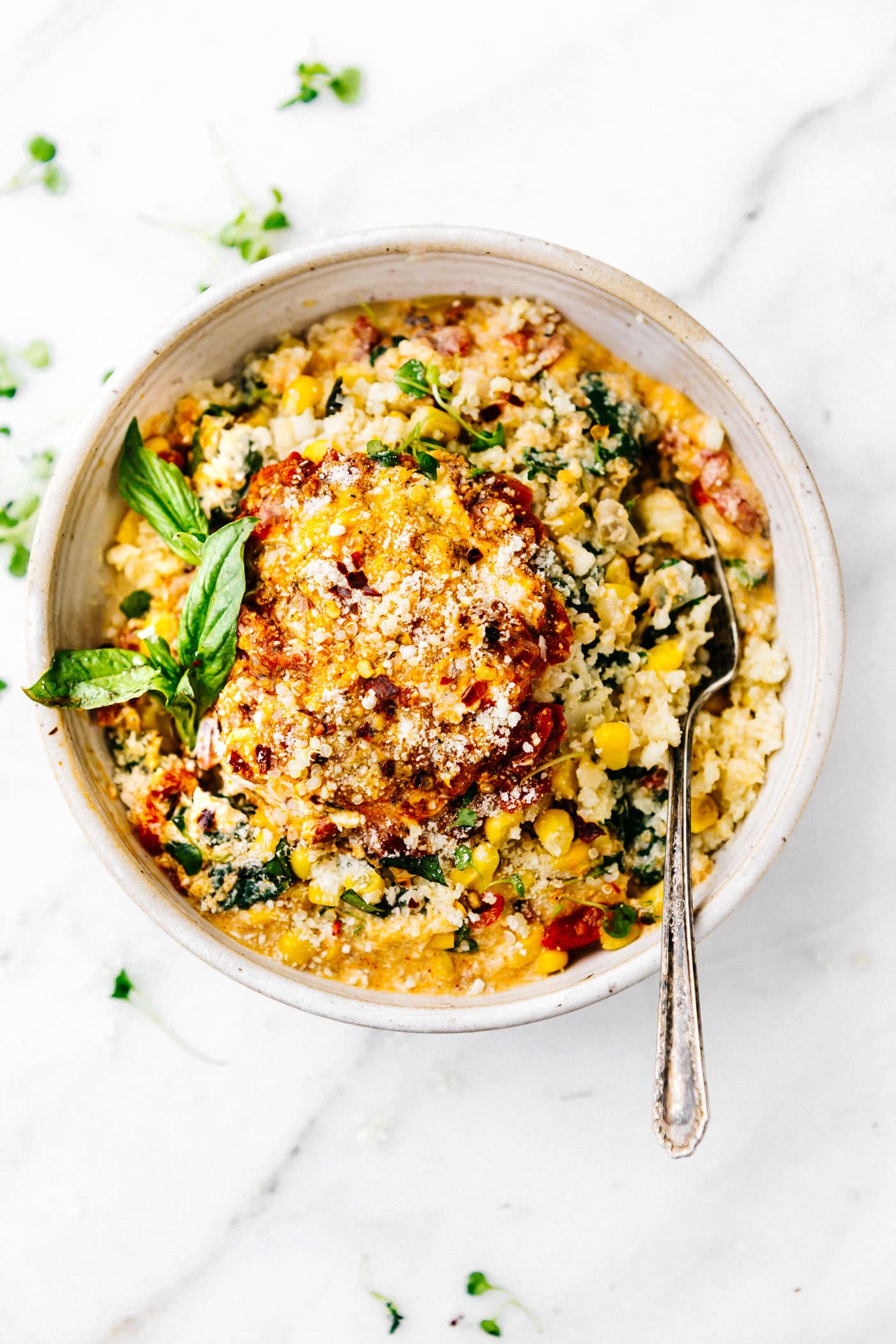 This Creamy Sweet Corn Cauliflower Grits recipe makes for a flavor packed one pot meal! Vegetarian Comfort food made lighter and healthier! Cauliflower riced into "grits" with sweet corn, Gruyere cheese, spinach, basil, onion, and more! Ready in 30 minutes