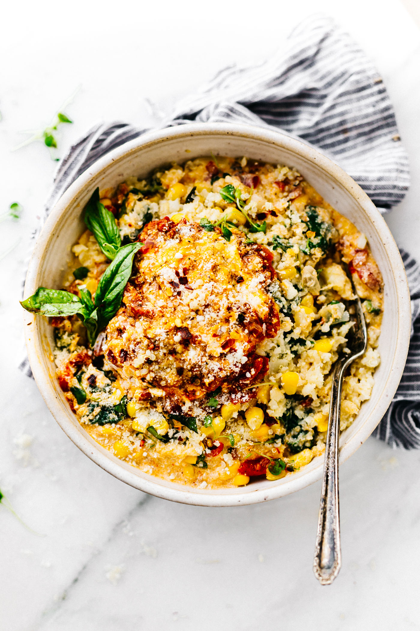 This Creamy Sweet Corn Cauliflower Grits recipe makes for a flavor packed one pot meal! Vegetarian Comfort food made lighter and healthier! Cauliflower riced into "grits" with sweet corn, Gruyere cheese, spinach, basil, onion, and more! Ready in 30 minutes