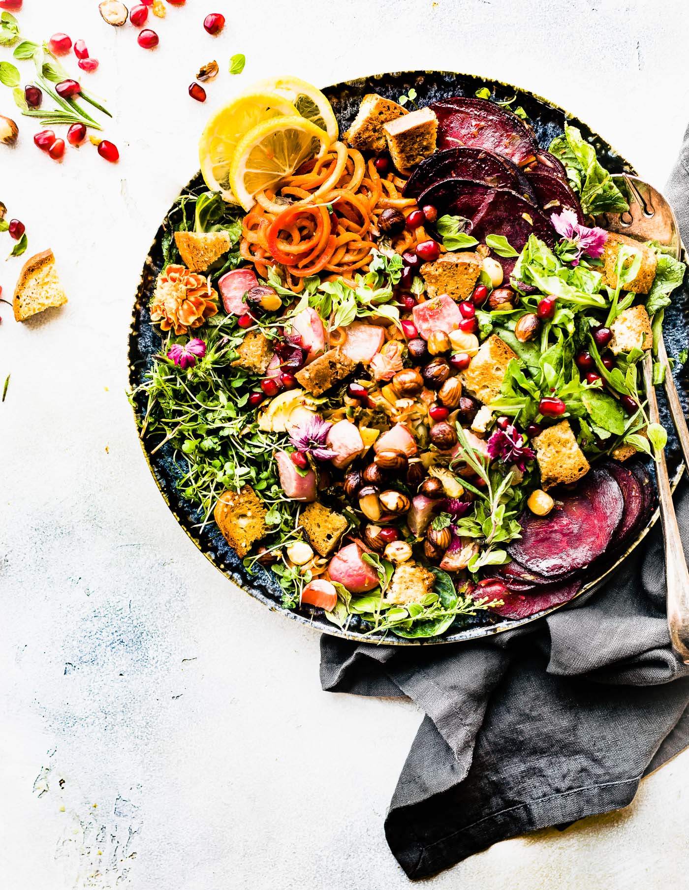Overhead view herb roasted panzanella fall salad with croutons in black stone bowl.