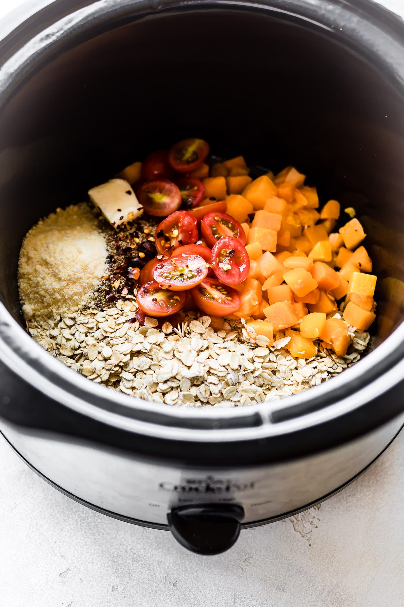 All ingredients for savory slow cooker oatmeal in black slow cooker