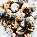 Several dark chocolate amaretto cake bites drizzled with almond butter
