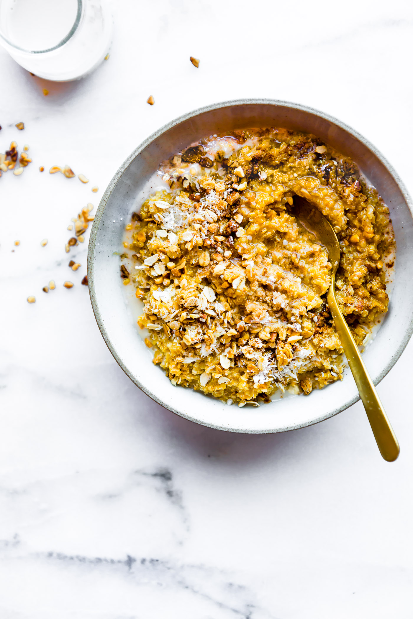 Overhead view stone bowl filled with serving of creamy pumpkin quinoa breakfast.